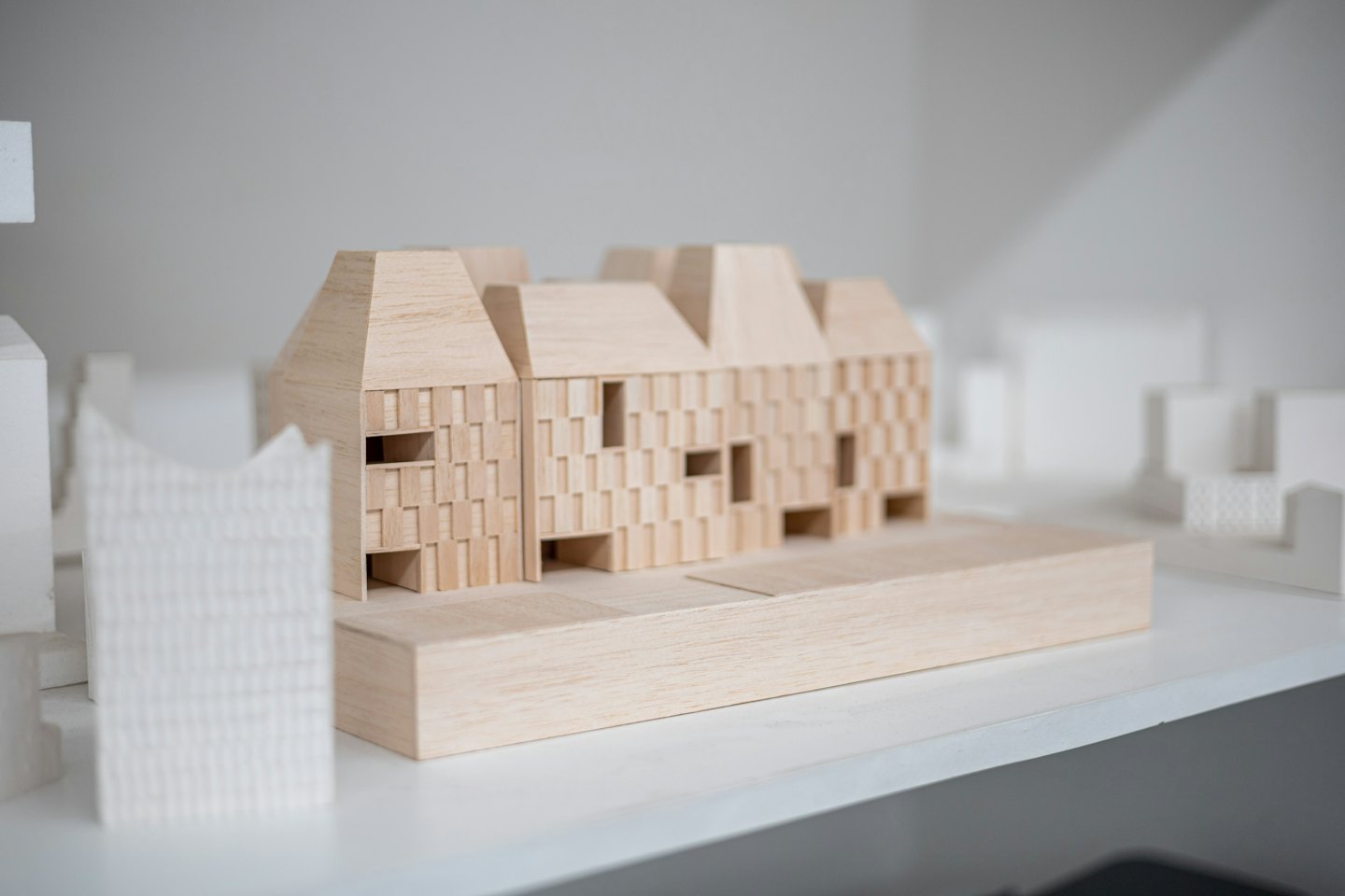 Trearkitektonisk modell av en flerboligbygning i studio.