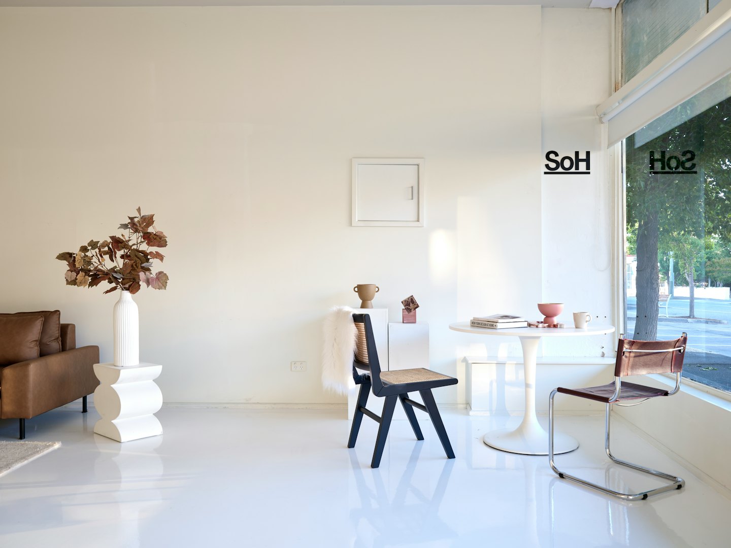 Moderne kontorlobby med møbler fra midten av århundret og store vinduer.